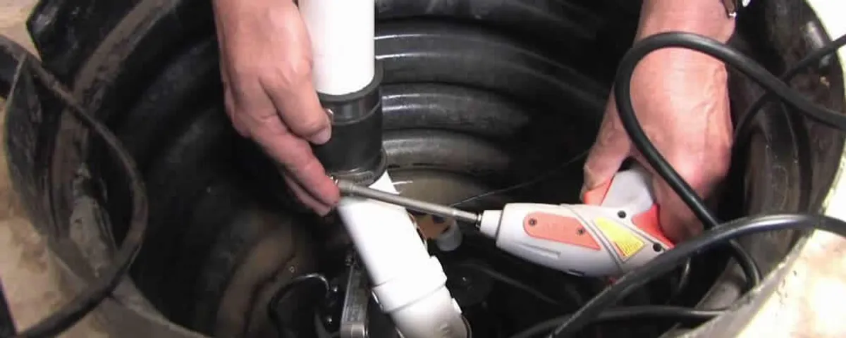 Sump pump installation technician connecting PVC discharge piping in Jacksonville, FL